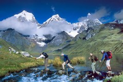 Trekkers cross the outlet stream of Lake Carhuacocha (13,600 feet) in the Cordillera Huayhuash, Peru, South America. Trekkers cross the outlet stream of Lake Carhuacocha (13,600 feet) in the Cordillera Huayhuash, Peru, South America.